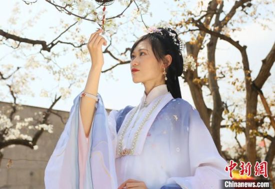 圖為蘭州青年身穿漢服在百年梨園賞景?！「哒?攝