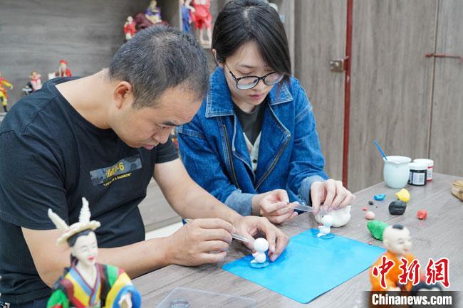 <a target='_blank'  data-cke-saved- >中新社</a>記者(右)現(xiàn)場(chǎng)體驗(yàn)面塑制作過(guò)程。　陳爭(zhēng)強(qiáng) 攝