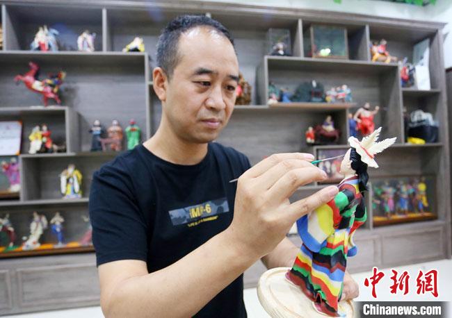 圖為安秋平正在創(chuàng)作代表隴南文縣民俗的《白馬人》作品?！「哒?攝