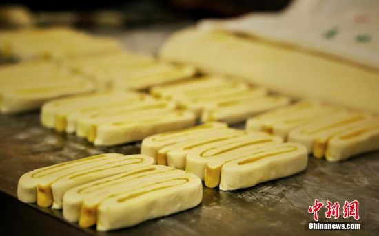 圖為面劑被涂上胡麻油，切成條狀用作月餅的花型制作。張文 攝