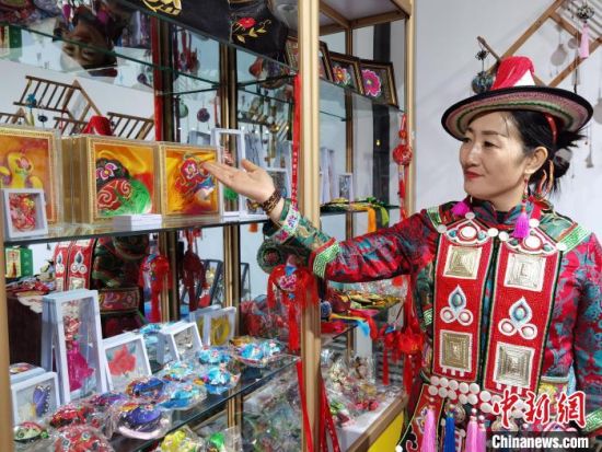 圖為身著民族服飾的隴原巧手展示手工藝品。(資料圖) 徐雪 攝
