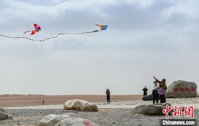 圖為市民正在陽關(guān)景區(qū)放風(fēng)箏。　王斌銀 攝