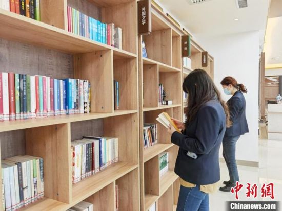 圖為在甘肅公航旅建設(shè)集團(tuán)有限公司的職工書屋，職工挑選書籍?！⌒煅?攝
