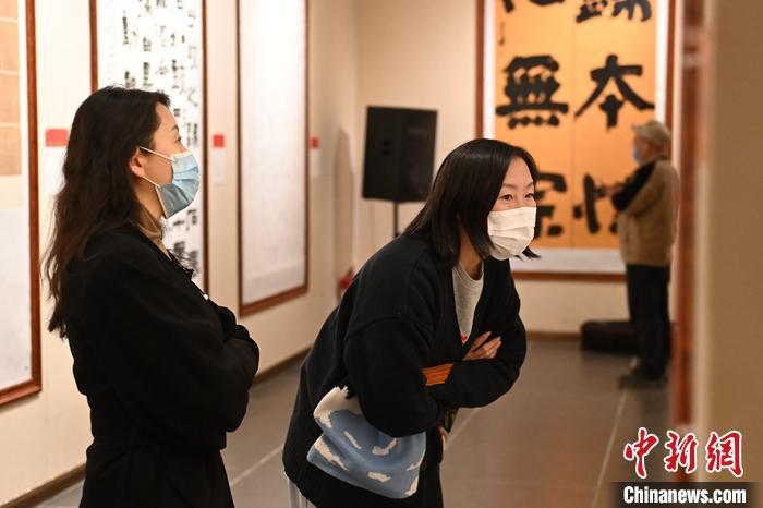 圖為甘肅蘭州，參展書(shū)法作品吸引參觀者。 中新社記者 李亞龍 攝