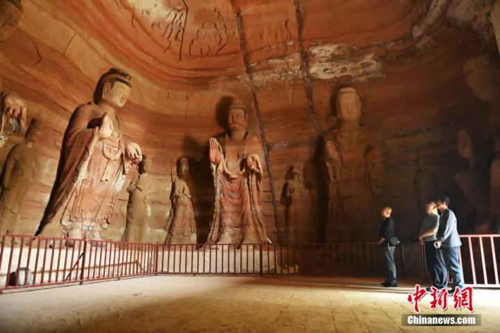 7月15日，游人參觀甘肅省平?jīng)鍪袥艽h百里石窟長廊中的南石窟寺1號窟。百里石窟長廊位于涇川縣境內(nèi)，由512個石窟、5眼窟中石井組成，現(xiàn)存王母宮石窟、鳳凰山石窟、南石窟寺、丈八寺石窟、羅漢洞石窟、太山寺石窟等規(guī)模較大的石窟群，還有數(shù)量眾多的小石窟群。南石窟寺開鑿于北魏永平三年，其中1號窟屬于大型七佛窟，七佛高達(dá)6米。中新社記者 李亞龍 攝