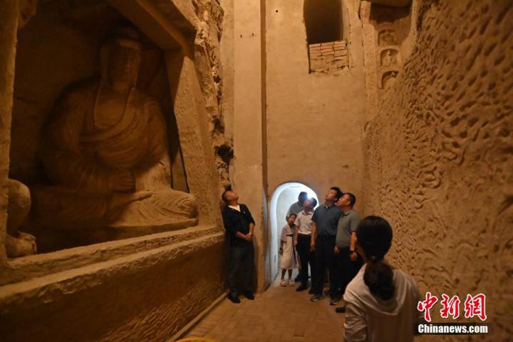 7月15日，游人參觀甘肅省平?jīng)鍪袥艽h百里石窟長廊中的王母宮石窟。百里石窟長廊位于涇川縣境內(nèi)，由512個石窟、5眼窟中石井組成，現(xiàn)存王母宮石窟、鳳凰山石窟、南石窟寺、丈八寺石窟、羅漢洞石窟、太山寺石窟等規(guī)模較大的石窟群，還有數(shù)量眾多的小石窟群。王母宮石窟又名千佛洞，該窟設(shè)計宏大，造像生動，窟內(nèi)擁有造像數(shù)百尊，是較為珍貴的佛教文化歷史遺存。中新社記者 李亞龍 攝</p>
<p>
