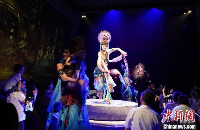 《樂(lè)動(dòng)敦煌》是全球首部洞窟式沉浸體驗(yàn)劇，利用真人與數(shù)字影像虛實(shí)交換實(shí)現(xiàn)沉浸式體驗(yàn)。圖為2023年8月28日晚，《樂(lè)動(dòng)敦煌》演出。(資料圖)中新社記者 毛建軍 攝